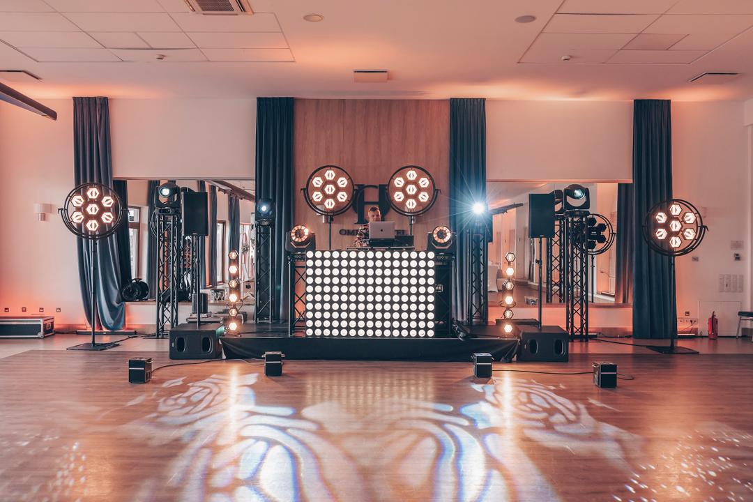 Rzeczywiste stanowisko DJ Premium: oświetlenie, nagłośnienie QSC, podest i sceniczne wytwornice iskier przed sceną.